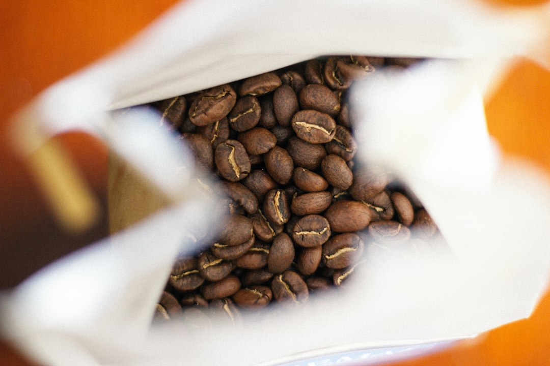 Frisch geröstete Kaffeebohnen von oben in einer geöffneten Kaffeetüte
