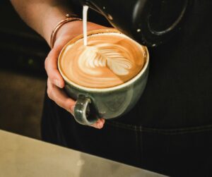 Barista bereitet ein Kaffeegetränk zu, Symbolfoto zum Kaffee-Preisvergleich