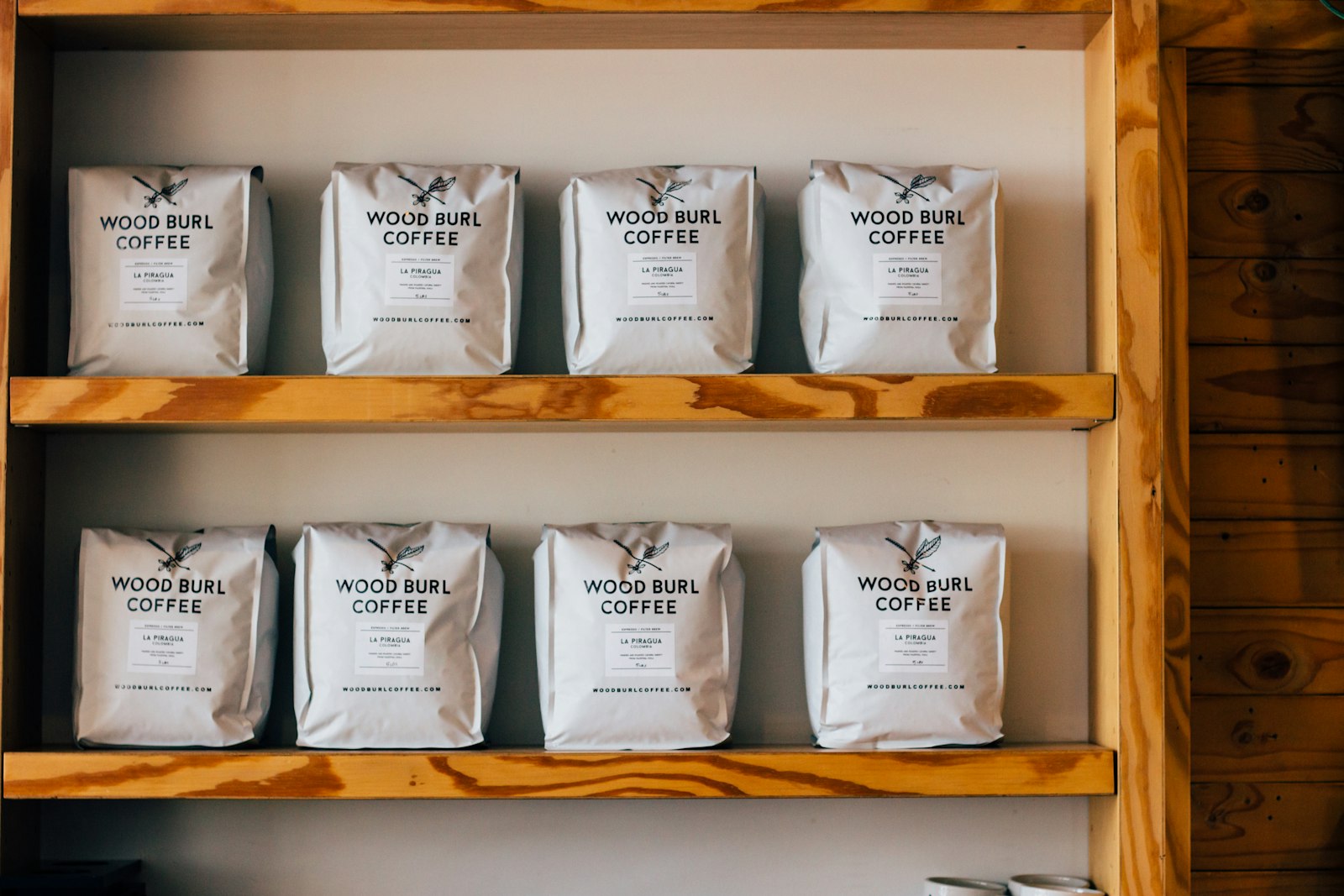 Verpackter Röstkaffee in Tüten auf einem Holzregal