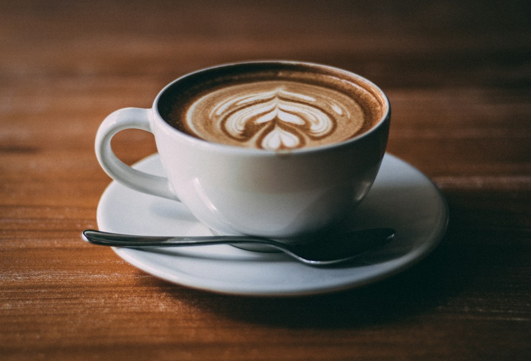 Cappuccino mit Milchschaum in einer Tasse auf Untertasse