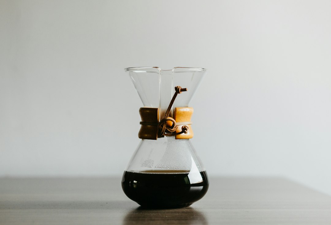 Chemex-Karaffe aus Glas mit Holzmanschette und Lederband, unten mit Filterkaffee gefüllt