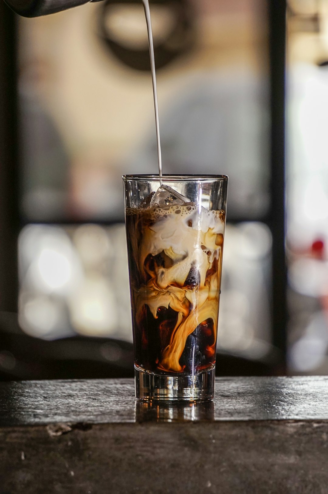 Glass of cold brew on ice, topped up with milk