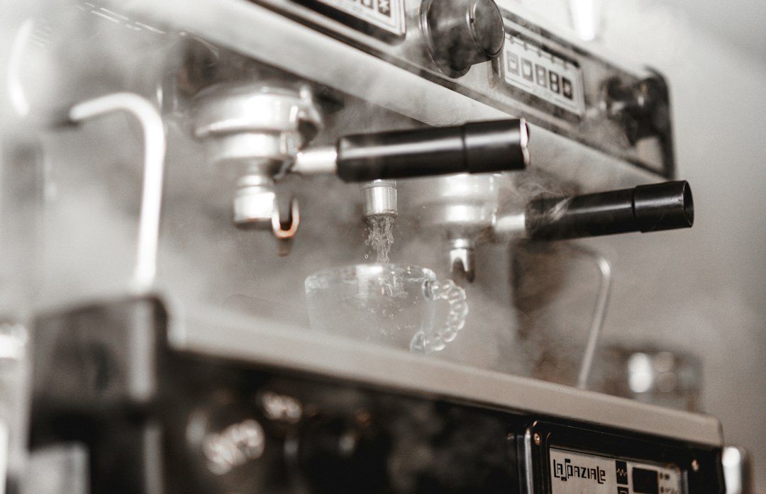 Nahaufnahme einer Kaffeemaschine, aus der Dampf aufsteigt