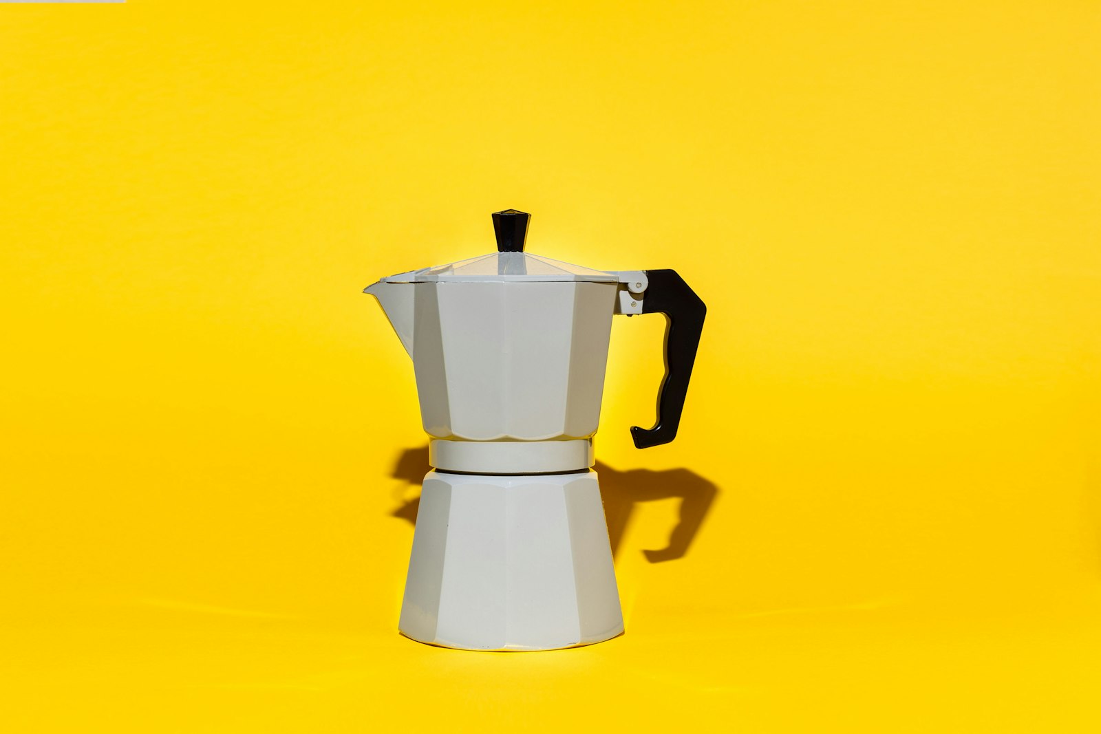 Aluminium moka pot against a yellow background