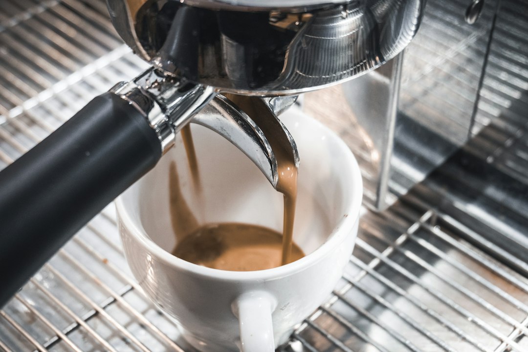 Schwarze Espressomaschine im Cafébetrieb, Barista bereitet eine Bestellung zu
