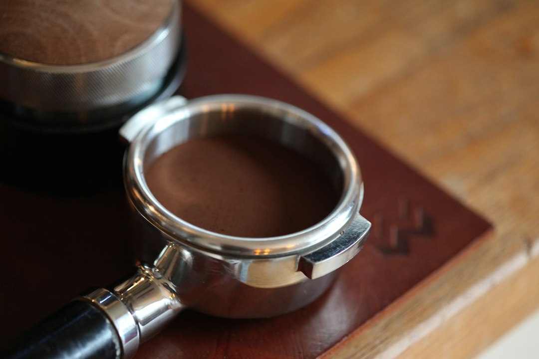 Gepresstes Kaffeepulver als Puck in einem bodenlosen Siebträger