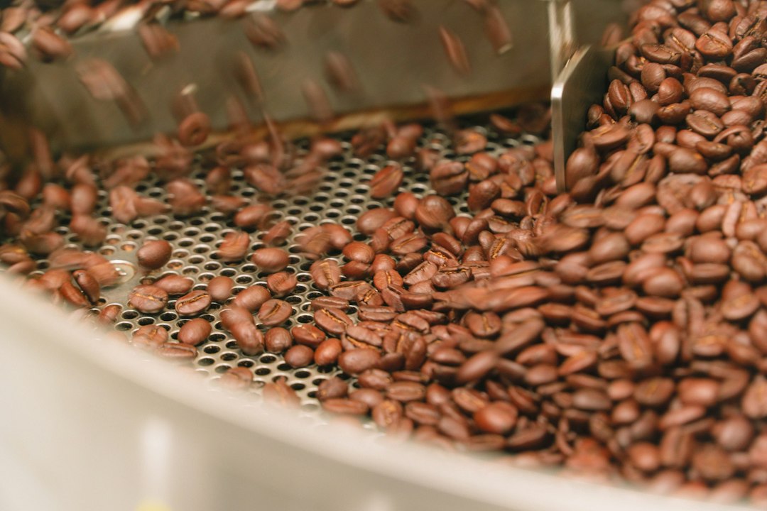 Brown roasted coffee beans in a white ceramic bowl