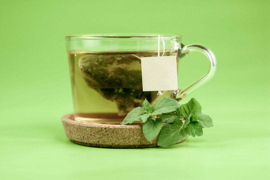 Grüner Tee mit Blättern im Glas