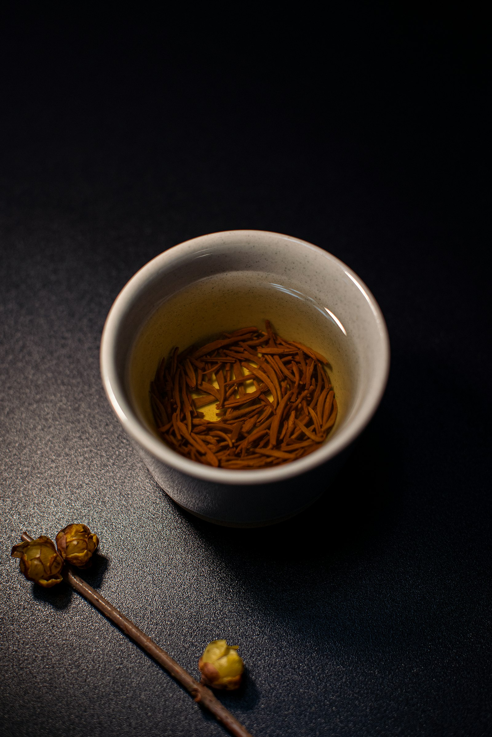 Hojicha in einer kleinen weißen Keramikschale auf dunklem Untergrund