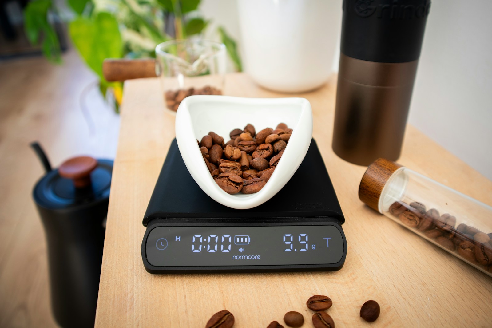 Digitale Kaffeewaage zeigt 9,9 Gramm Kaffeebohnen in einer weißen Schale