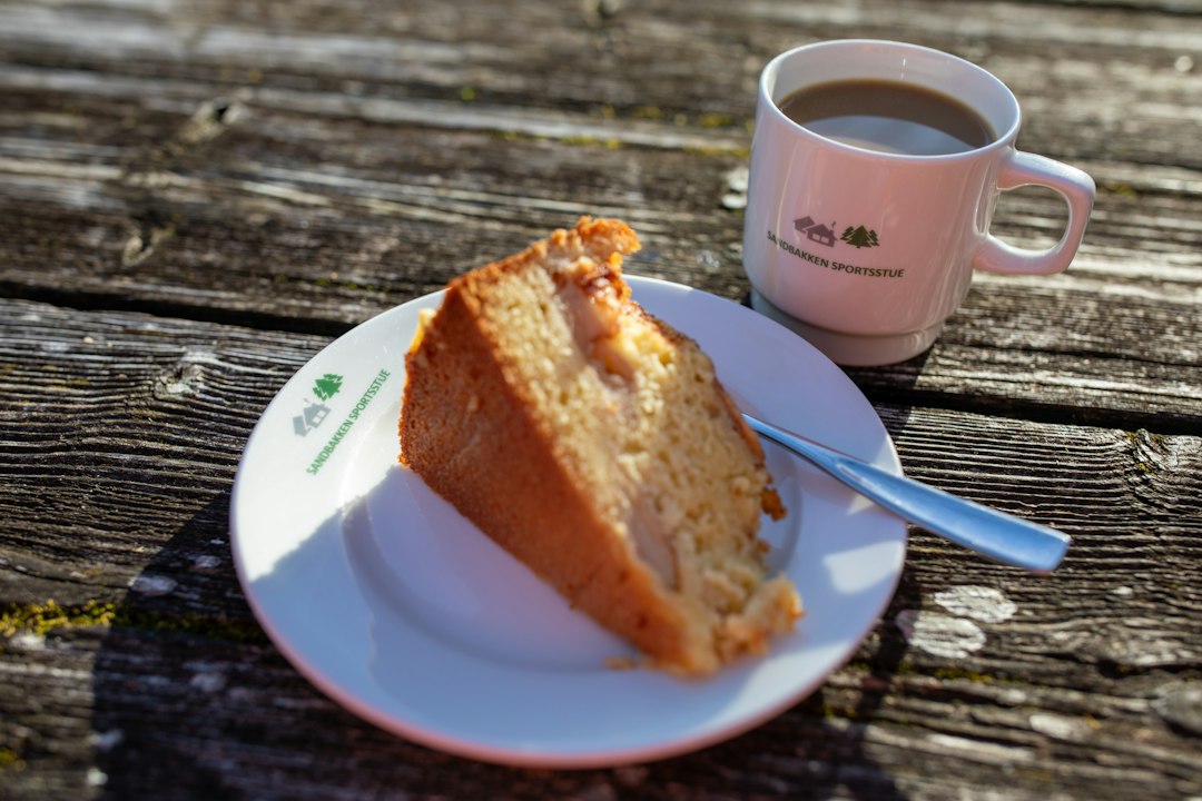 Ein Stück Kuchen und eine Tasse Kaffee auf einem Holztisch