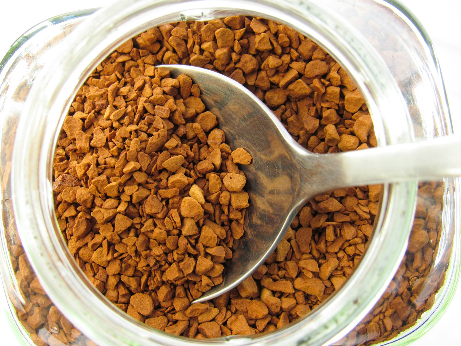 Teelöffel mit löslichem Kaffee über einem Glas