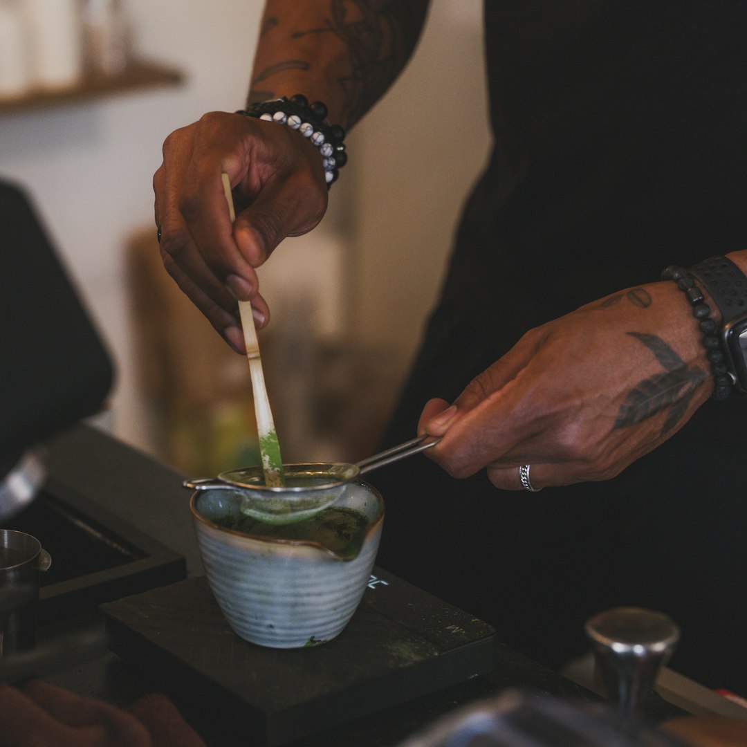 Barista bereitet einen Matcha Latte zu