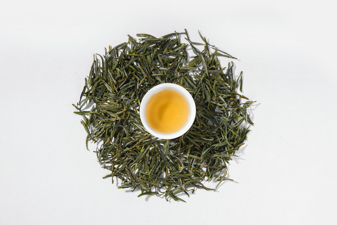 Sencha zubereiten: Tasse mit hellgrünem Aufguss vor weißem Hintergrund