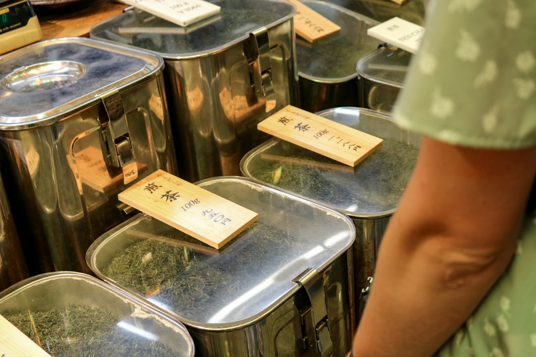 Metalldosen mit losem Tee und Holzschildern in einem Teegeschäft: Hojicha und andere japanische Grüntees