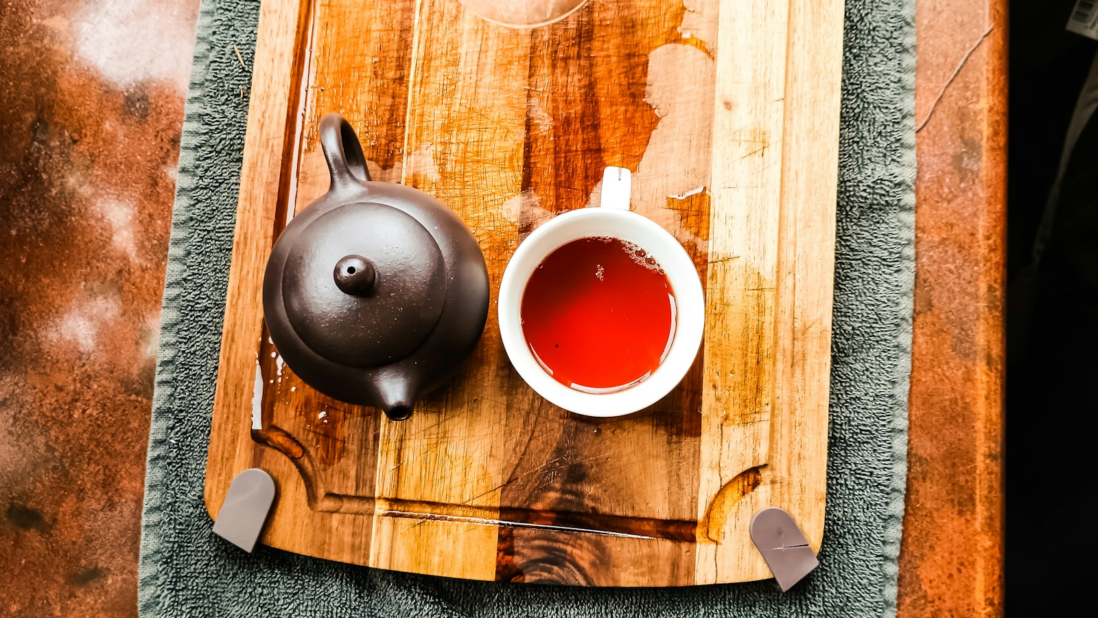 Teapot and a cup of tea on a wooden tray