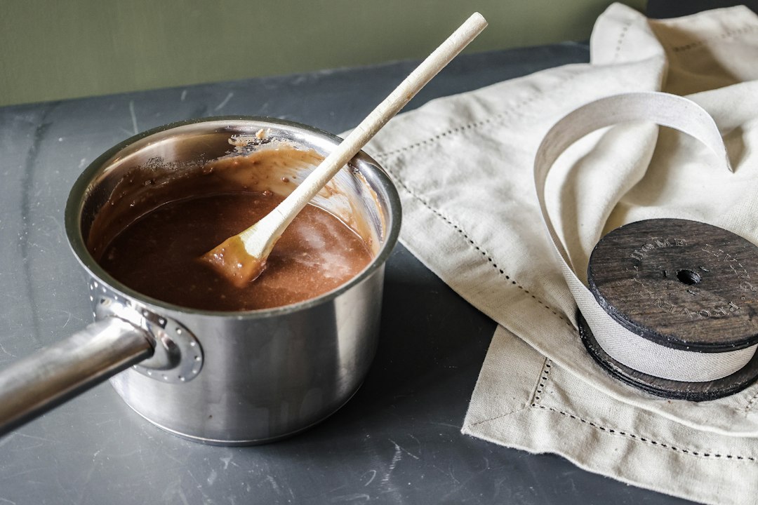 A pan of chocolate and a wooden spoon on a table