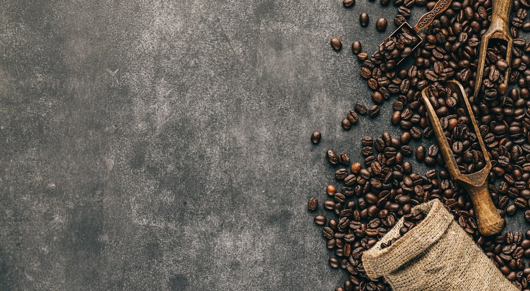 Umgekippter Beutel mit gerösteten Kaffeebohnen und einer Schaufel